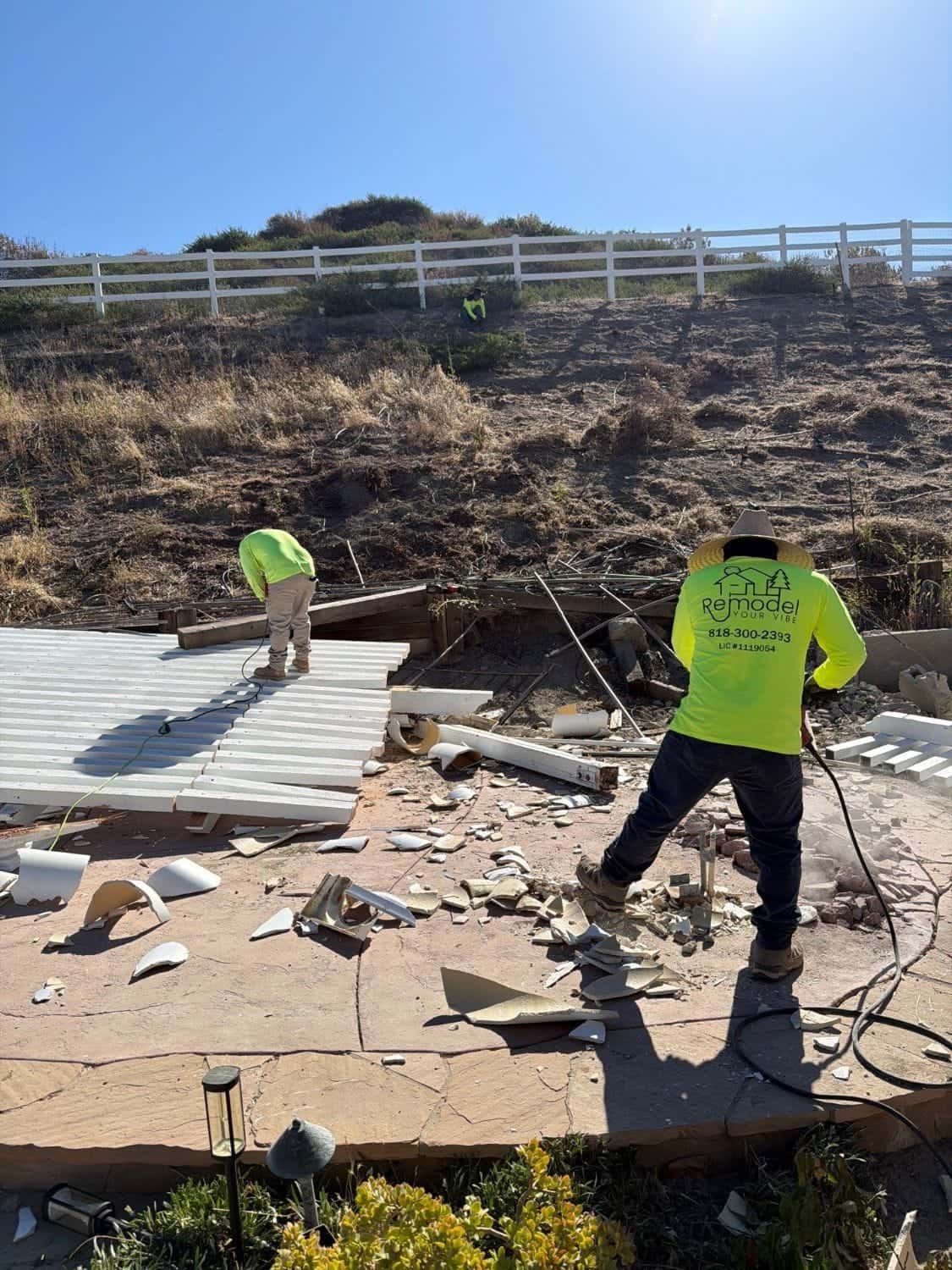 Crew tearing out an old patio cover before the rebuild