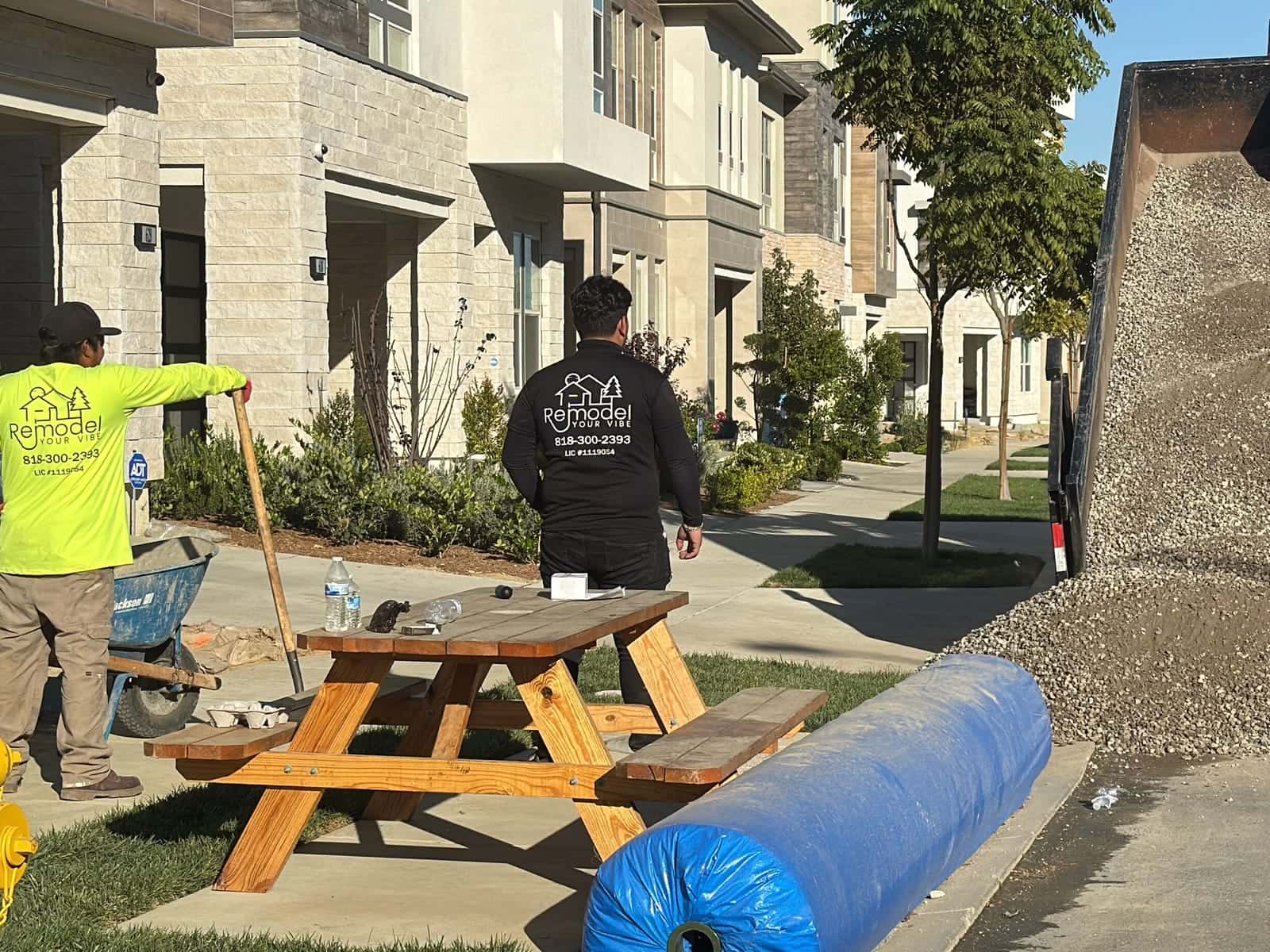 Crew staging gravel and a turf roll at the curb before install