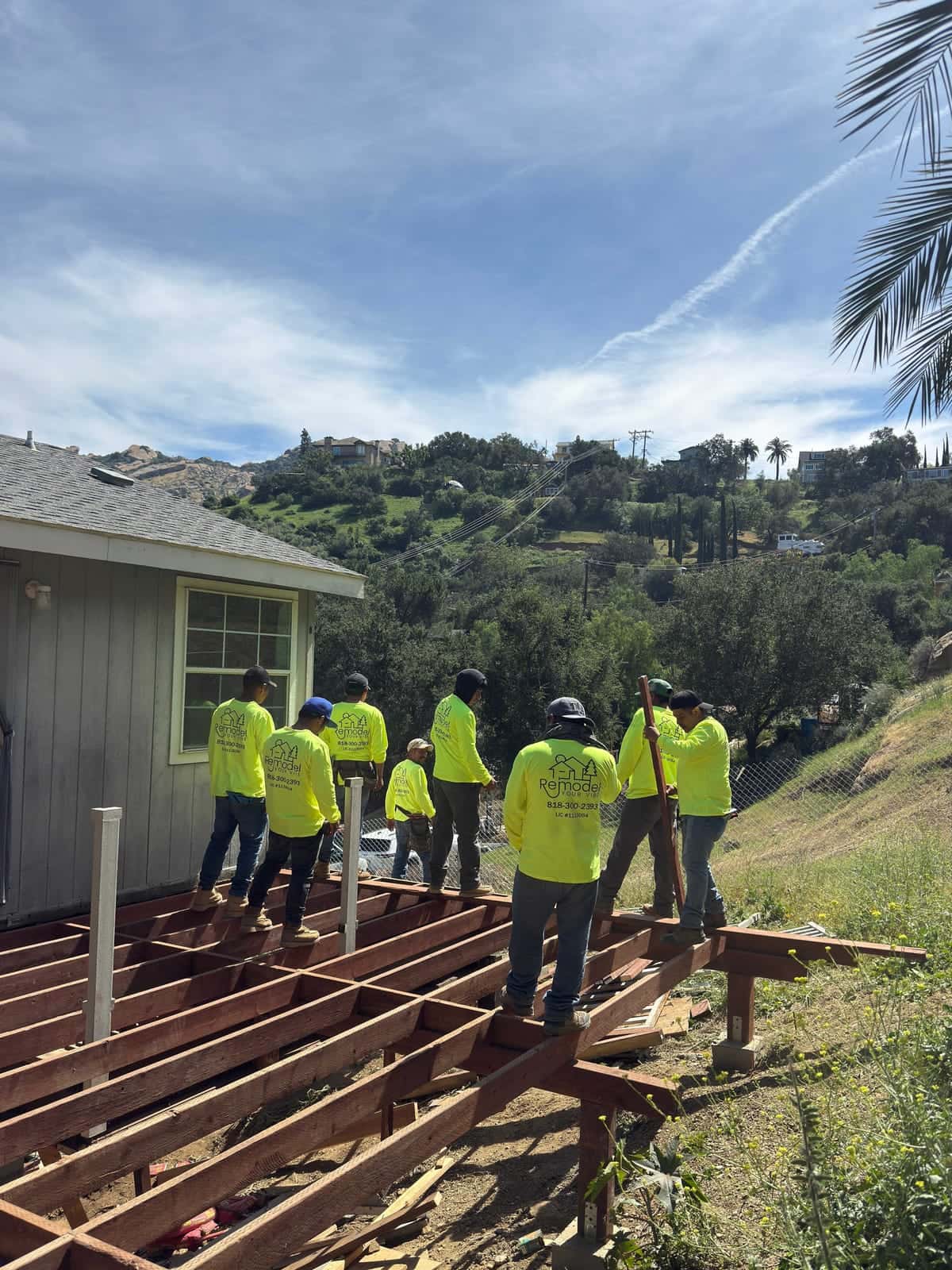Crew framing a new deck on a hillside lot