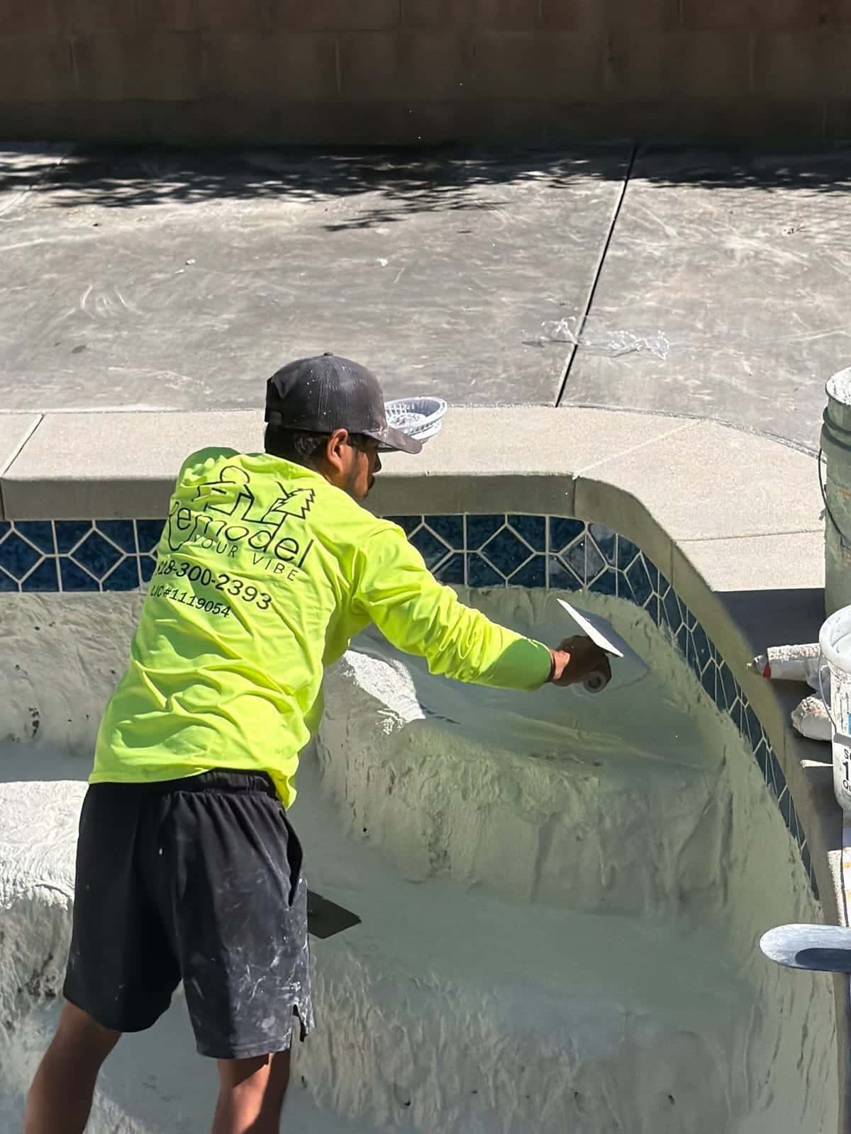 Shaping plaster on pool steps under blue tile