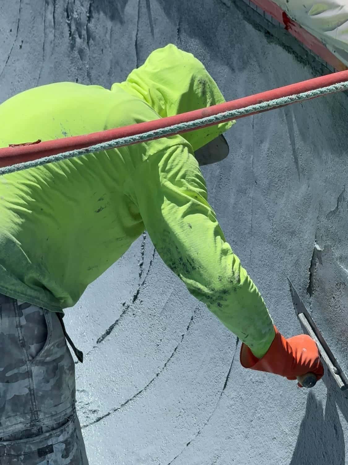 Plasterer working a pool wall from above