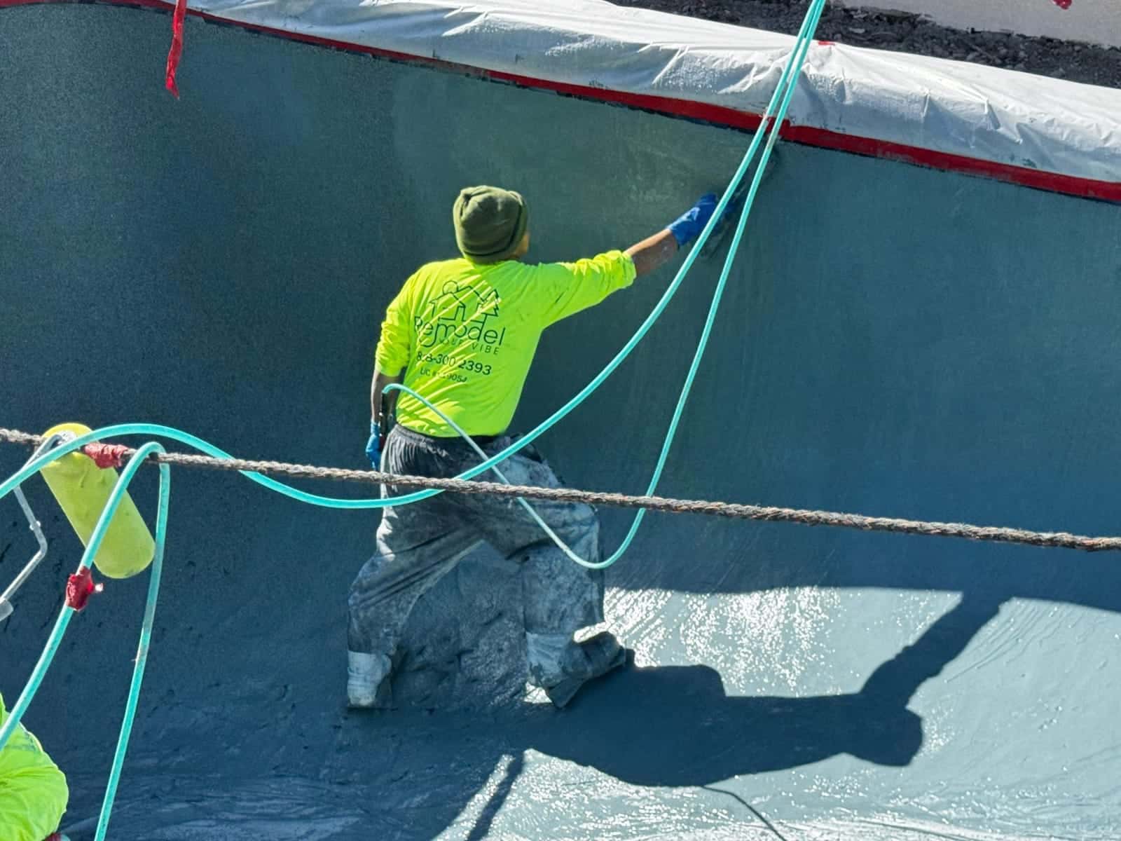 Crew member floating plaster on a pool wall