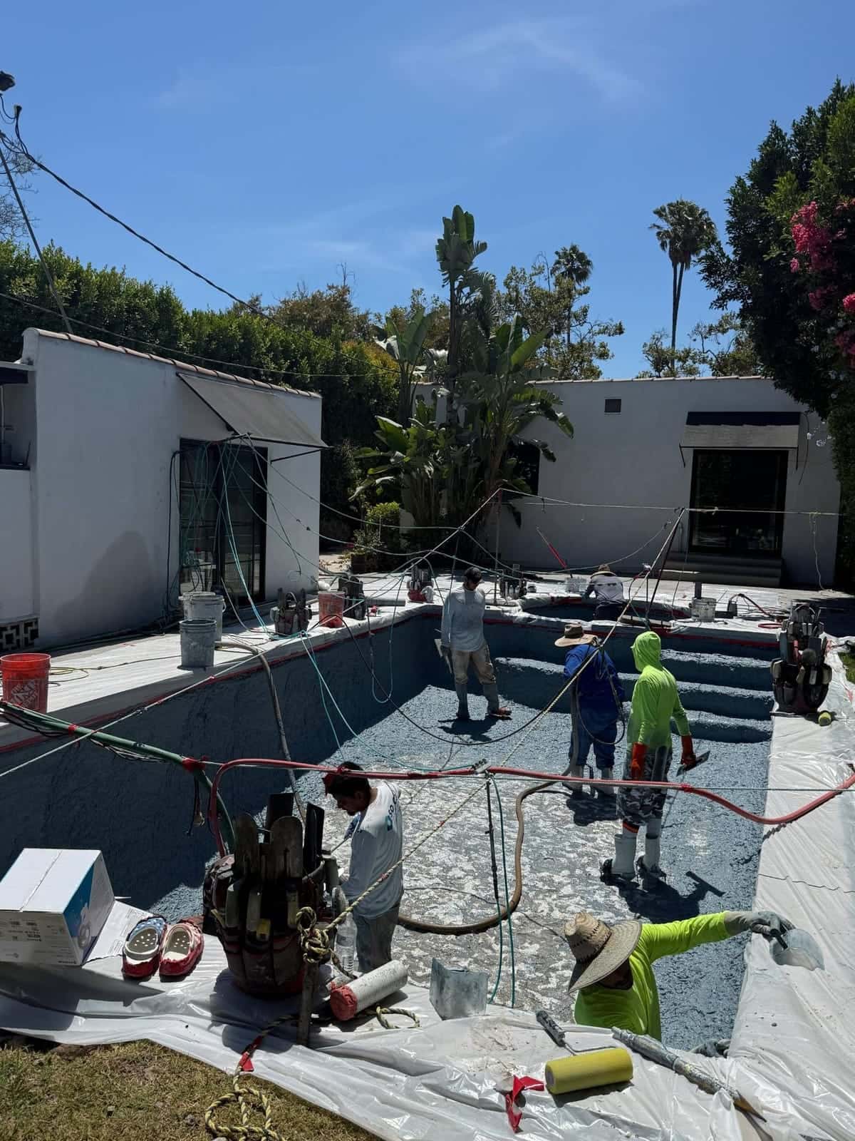 Pool replaster underway in a Spanish style backyard