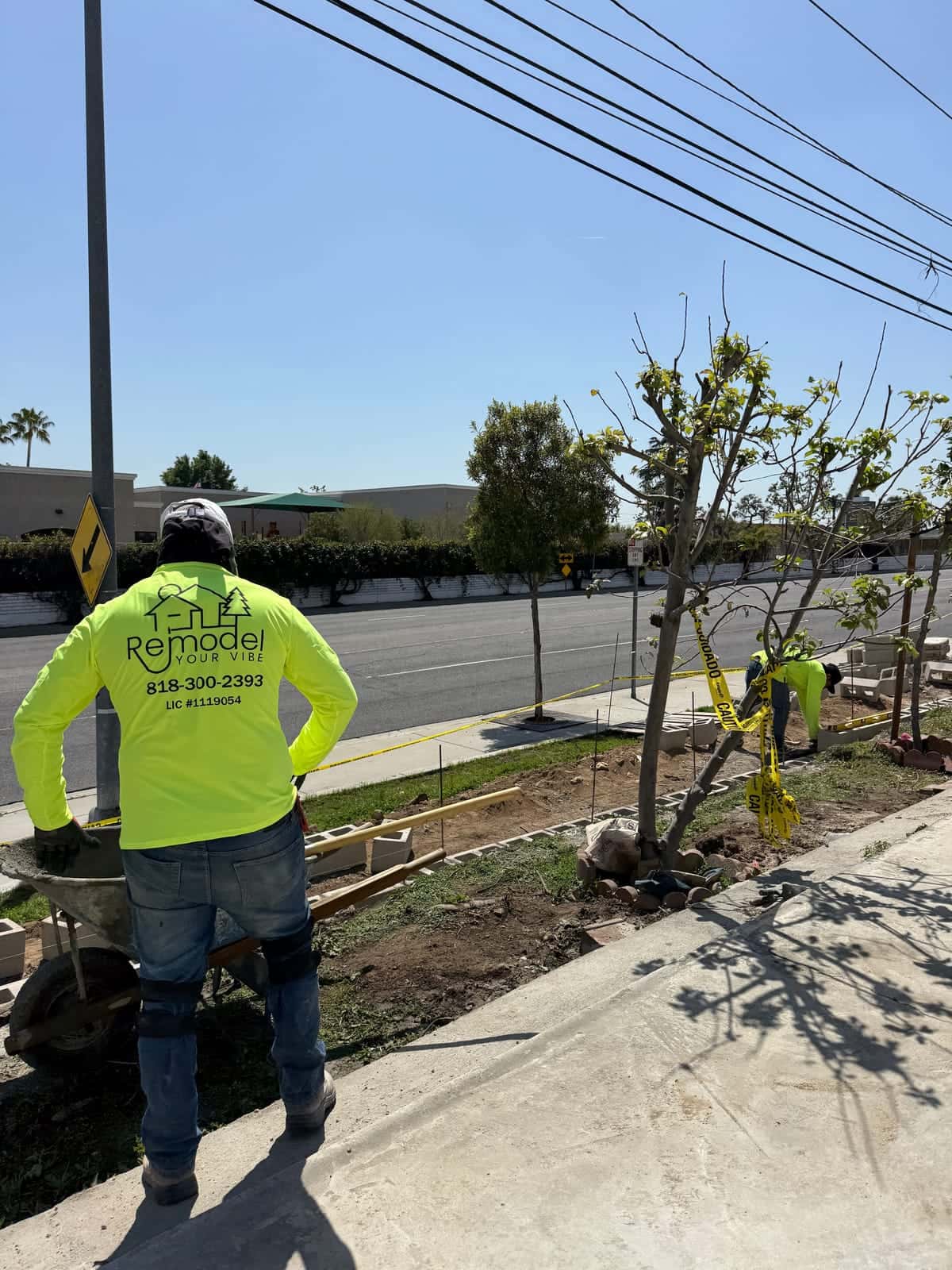 Crew building a low block border along a sidewalk parkway