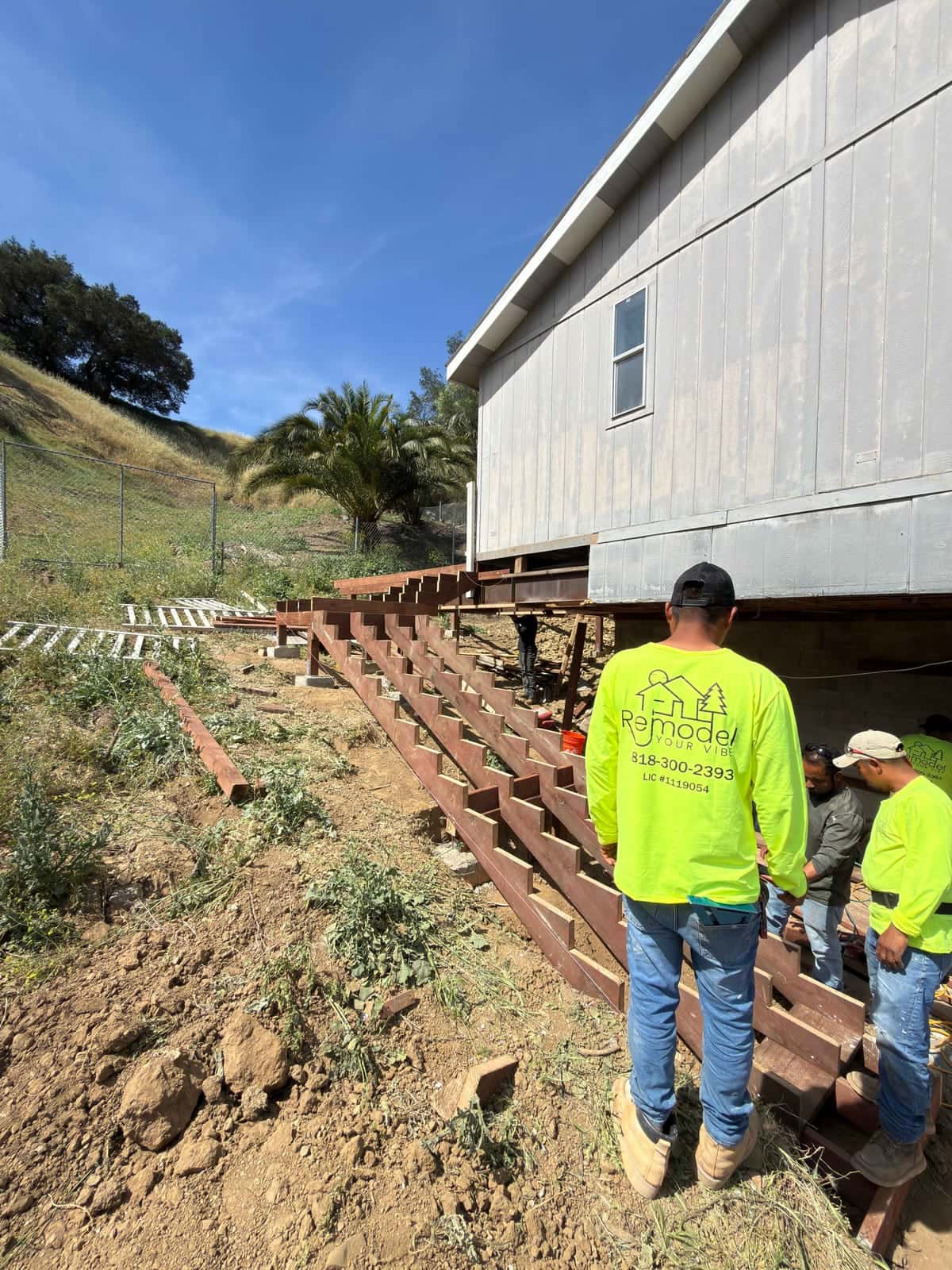 Crew building timber steps on a sloped yard