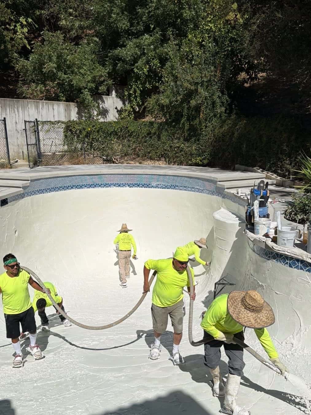 Full plaster crew working a pool shell together