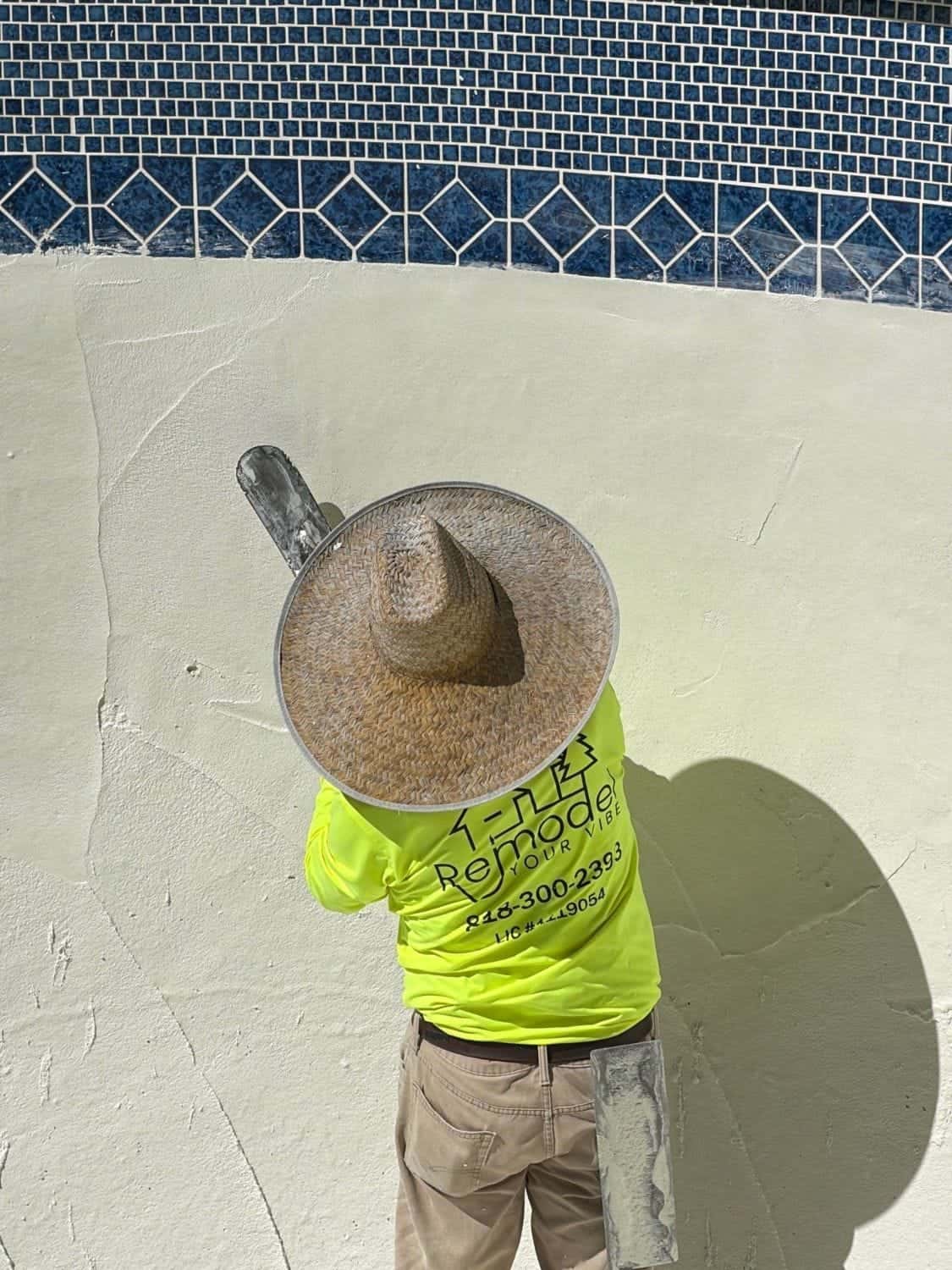 Overhead view of a plasterer smoothing a pool wall