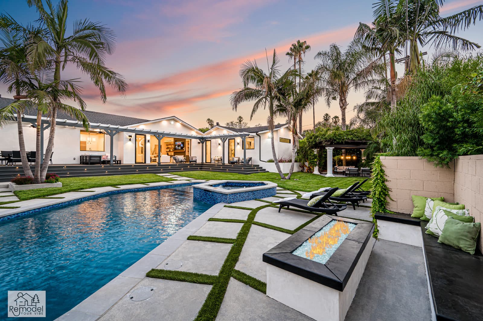 Twilight backyard with pool, raised spa, fire table, and lit home, a completed Remodel Your Vibe project