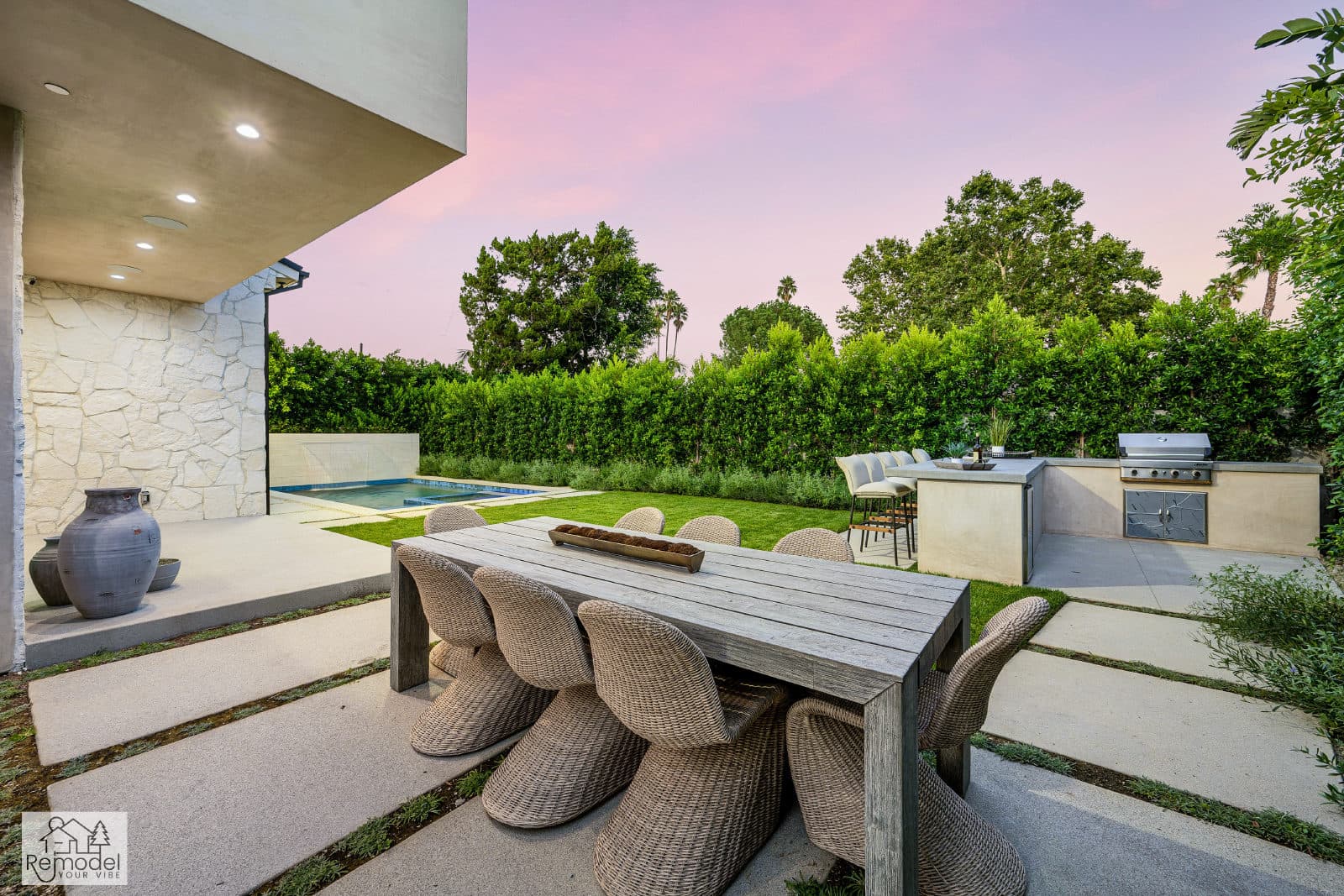 Twilight backyard with outdoor dining, pool, and built-in kitchen, a completed Remodel Your Vibe project